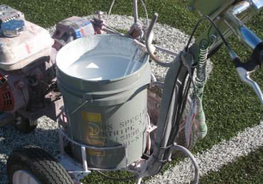 Spray apply removable striping line marking paint turf football field.