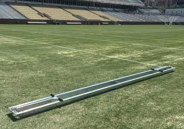 Straight line template stencil spray painting athletic field lines.