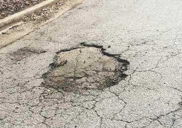 Asphalt pothole pavement damage repair.