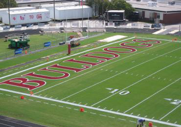 Red color football field end zone marking line striping paint.