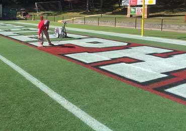 spray application of white red black field paint stencil.