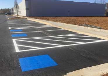 painting of brand new parking lot line marking paint in progress.