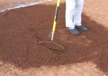 Dry infield dirt after treatment with water absorbing soil treatment product rain out.