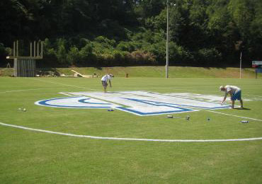 Connecting dots, connecting line and outlines and filling in paint to finish football field midfield logo.