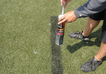 Aerosol paint remover synthetic field turf spray wand.