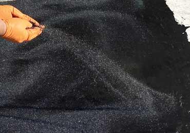 black sand for patching repairing asphalt pot hole damage.