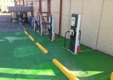Green concrete overlay coating electric car vehicle charging spot yellow parking lot EV marking paint.
