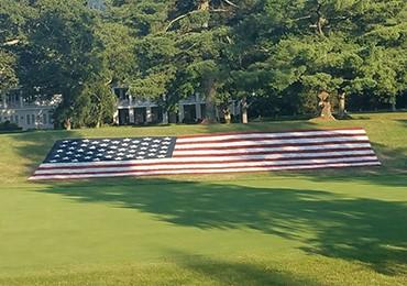 US flag painted with USSC stencil aerosol paint on golf course fairway PGA tournament.