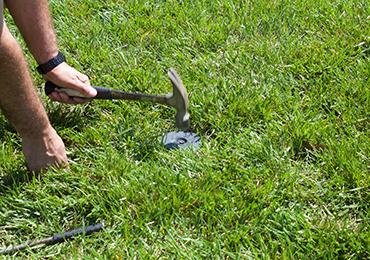 use rubber mallet hammer to install soccer ground sockets in soccer field.