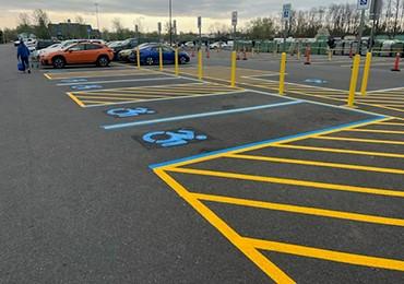 Painting handicap parking lot with instant dry blue traffic paint.