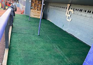 painting used damaged faded synthetic turf in baseball field dugout to give fresh green look with permanent paint.