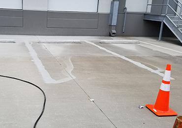 old paint removal surface preparation with pressure before parking lot painting.