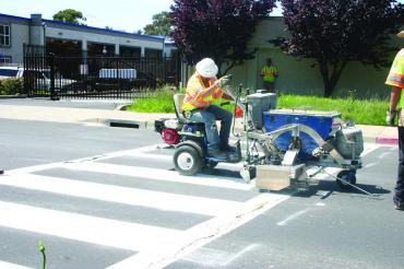 Cross walk painted with white solid thermoplastic paint Promelt graco machine.