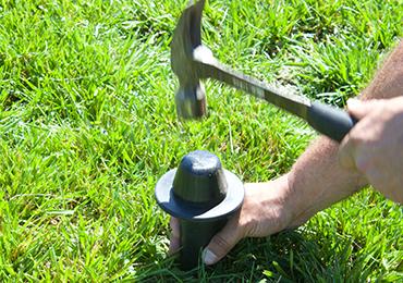 rubber mallet hammer to install football field ground sockets.