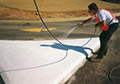 Liquid thermoplastic paint applied with conventional traffic line marking airless spray equipment.