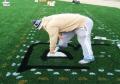 Painting of permanent logo on synthetic field turf.