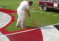 Bright Red white college mid field logo painting line striping logo paint.