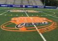 Football field event logo painted on synthetic turf football field.