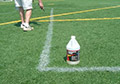 Spray application of paint remover on paint lines to be removed on artificial grass turf fields.