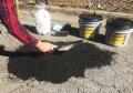 Spread compact asphalt cold patch repair material with trowel.