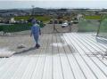 white heat reflective elastomeric flexible coating applied on metal roof.
