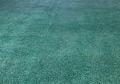 Old faded synthetic indoor outdoor field turf artificial grass painted green looking new.