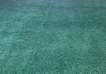 Old faded synthetic indoor outdoor field turf artificial grass painted green looking new.