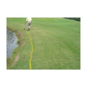 Bright yellow water hazard golf course marking paint.