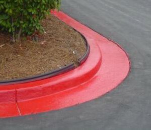Bright Red Curb Marking Near Landscaped Area