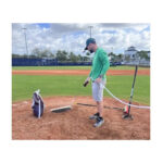 spraying water mist spray with wet striper on baseball ball field first clay mount infield.