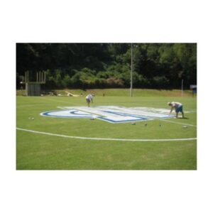 Circular White Logo Stencil Painted At Center Of Football Field