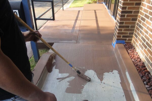 Person Painting a Concrete Sidewalk