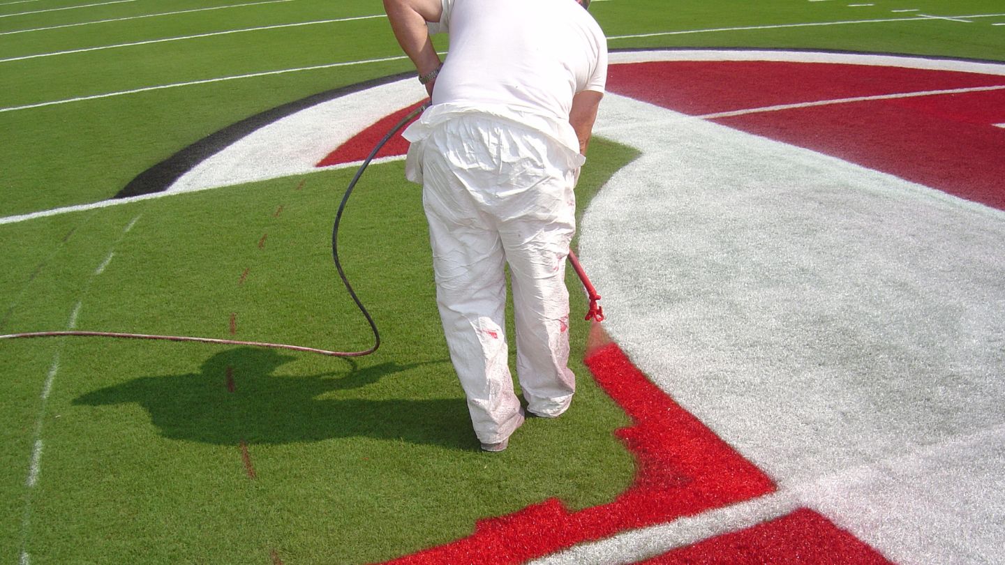 Person Painting Lines On A Football Field 
