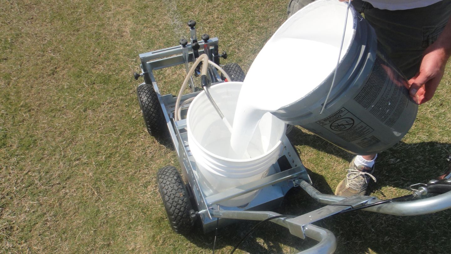  Pouring White Paint Into A Field Marking Machine 
